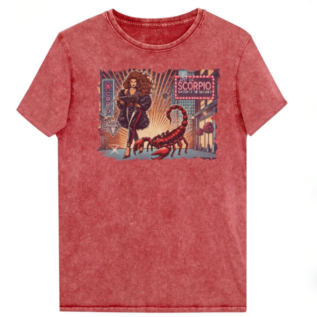 Flatlay of a unisex garnet red denim wash vintage t-shirt with a retro pop-art Scorpio graphic featuring a Brunette woman with long flowing hair, wearing a black pants with a red stripe down the side, a halterneck top and fur coat, next to a large red scorpion walking down the street past a shop window  captioned ‘Just an Scorpio, Master of the Smoulder'. Branded RedBlonde on inside neck and right shoulder
