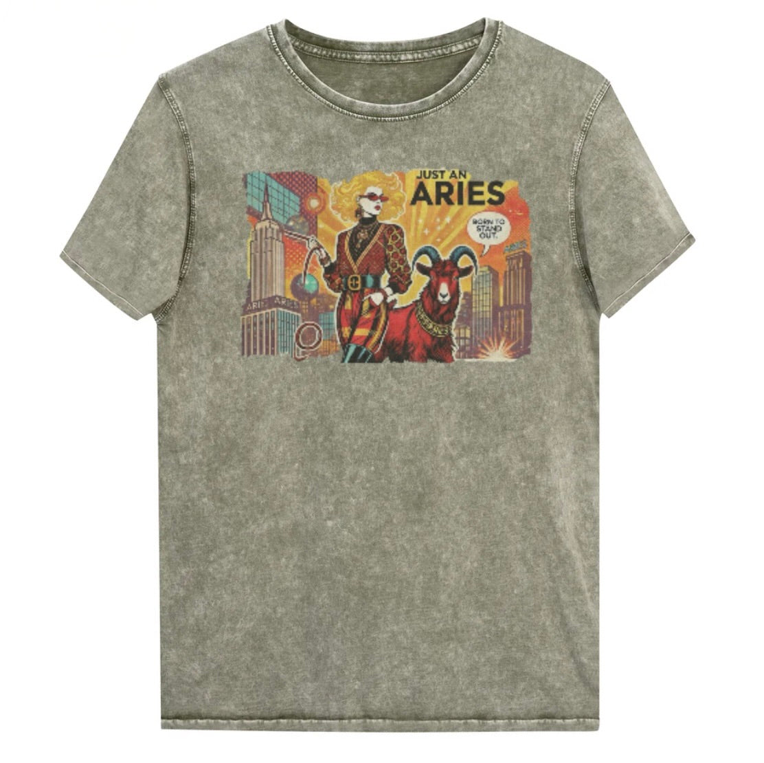 Flatlay of a unisex army green denim wash vintage t-shirt with a retro pop-art Aries graphic featuring a blonde woman, wearing a belted catsuit and high boots with one hand in her pocket, with a ram by her side and a city backdrop, captioned ‘Just an Aries, born to stand out'. Branded RedBlonde on inside neck and right sleeve