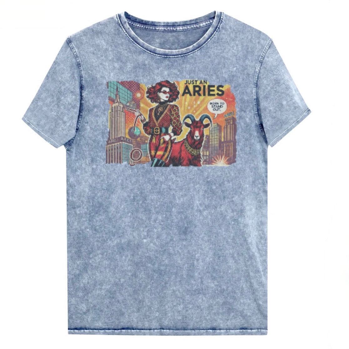Flatlay of a unisex blue denim wash vintage t-shirt with a retro pop-art Aries graphic featuring a redhead woman, wearing a belted catsuit and high boots with one hand in her pocket, with a ram by her side and a city backdrop, captioned ‘Just an Aries, born to stand out'. Branded RedBlonde on inside neck and right sleeve