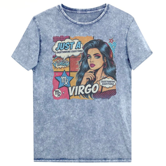 Flatlay of a unisex blue denim wash vintage t-shirt with a retro pop-art Virgo graphic featuring the head and shoulders of a dark long-haired woman, wearing an off the shoulder top with her hand on her chin, the backround is colourful chequered board with two bubble  captions ‘Just an Virgo, overthinking everything'. Branded RedBlonde on inside neck and right sleeve