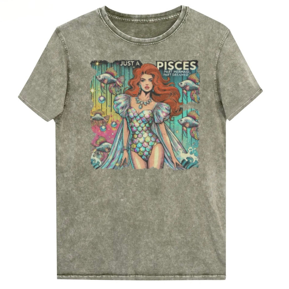 Flatlay of a unisex army green denim wash vintage t-shirt with a retro pop-art Pisces graphic featuring a redhead woman in a fish-scale dress, with fishes and bubbles backdrop, captioned ‘Just a Pisces, Part Mermaid, Part Dreamer'. Branded RedBlonde in red on inside neck and right shoulder