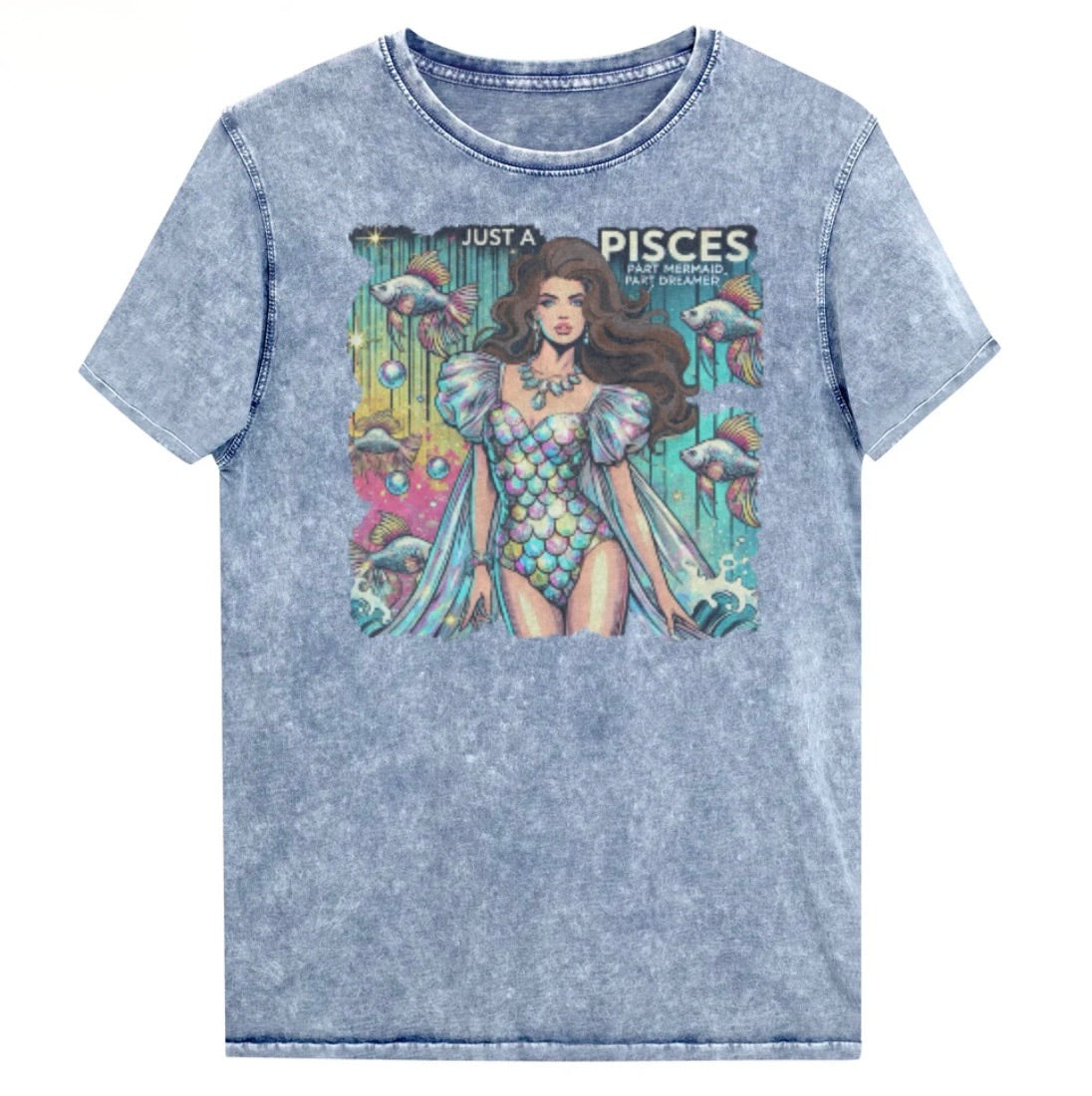 Flatlay of a unisex blue denim wash vintage t-shirt with a retro pop-art Pisces graphic featuring a brunette woman in a fish-scale dress, with fishes and bubbles backdrop, captioned ‘Just a Pisces, Part Mermaid, Part Dreamer'. Branded RedBlonde in red on inside neck and right shoulder
