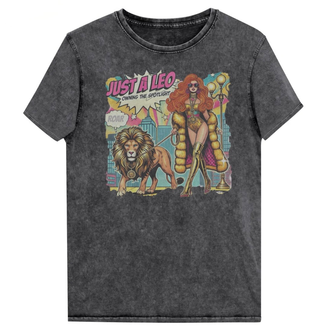 Flatlay of a unisex black denim wash vintage t-shirt with a retro pop-art Leo graphic featuring a long haired redhead woman in a gold swimsuit, gold over the knee boots, gold medallion and long fur coat, walking a lion on a leash wearing a gold medallion, with a caption bubble 'Roar', with a city and round bulb street lights in the background captioned ‘Just a Leo, Owning the Spotlight'. Branded RedBlonde in red on inside neck and right shoulder