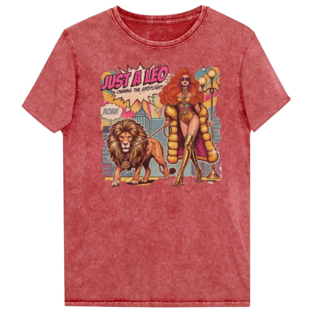 Flatlay of a unisex red garnet denim wash vintage t-shirt with a retro pop-art Leo graphic featuring a long haired redhead woman in a gold swimsuit, gold over the knee boots, gold medallion and long fur coat, walking a lion on a leash wearing a gold medallion, with a caption bubble 'Roar', with a city and round bulb street lights in the background captioned ‘Just a Leo, Owning the Spotlight'. Branded RedBlonde in red on inside neck and right shoulder