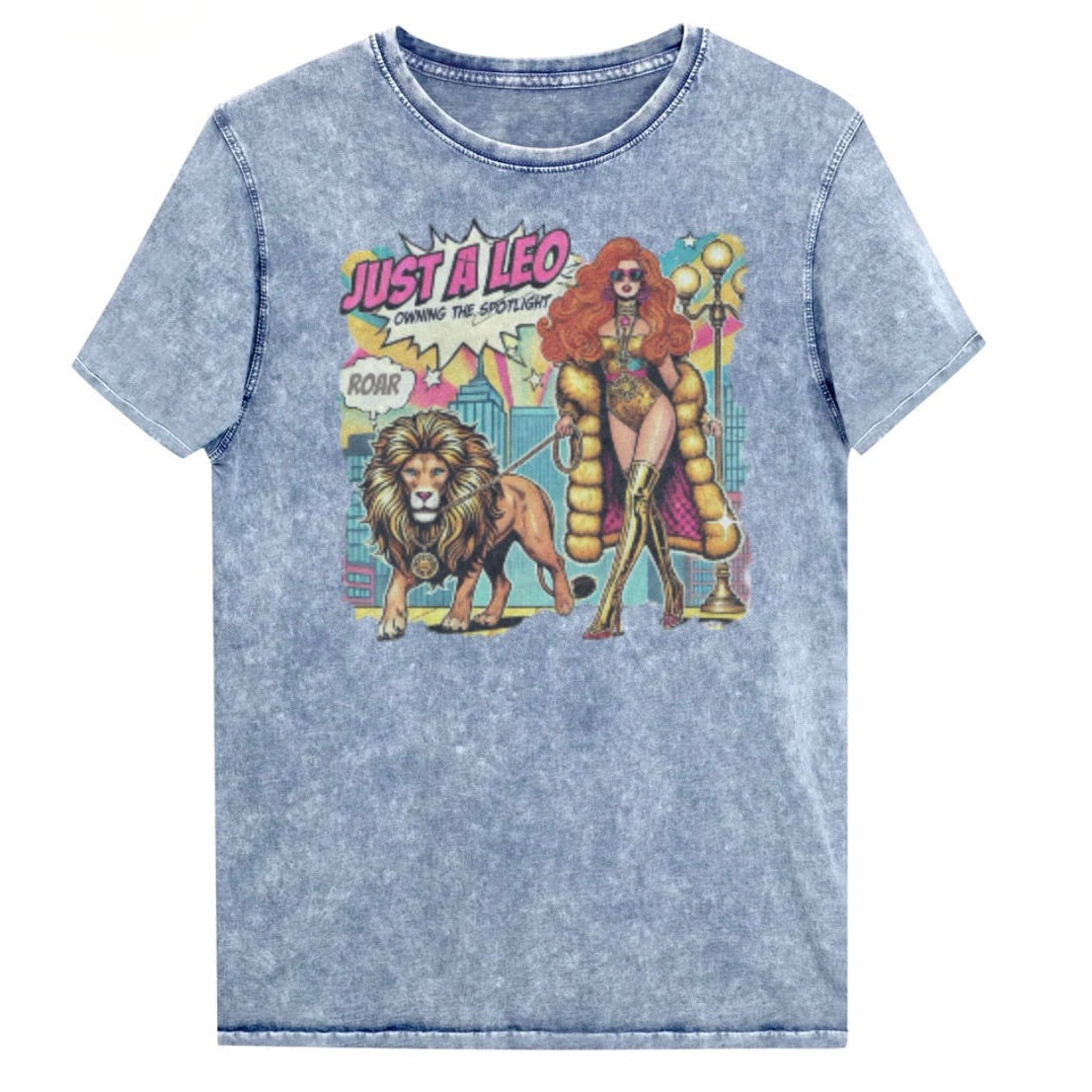 Flatlay of a unisex blue denim wash vintage t-shirt with a retro pop-art Leo graphic featuring a long haired redhead woman in a gold swimsuit, gold over the knee boots, gold medallion and long fur coat, walking a lion on a leash wearing a gold medallion, with a caption bubble 'Roar', with a city and round bulb street lights in the background captioned ‘Just a Leo, Owning the Spotlight'. Branded RedBlonde in red on inside neck and right shoulder