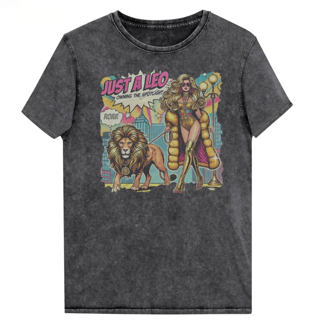 Flatlay of a unisex black denim wash vintage t-shirt with a retro pop-art Leo graphic featuring a long curly haired blonde woman in a gold swimsuit, gold over the knee boots, gold medallion and long fur coat, walking a lion on a leash wearing a gold medallion, with a caption bubble 'Roar', with a city and round bulb street lights in the background captioned ‘Just a Leo, Owning the Spotlight'. Branded RedBlonde on inside neck and right shoulder