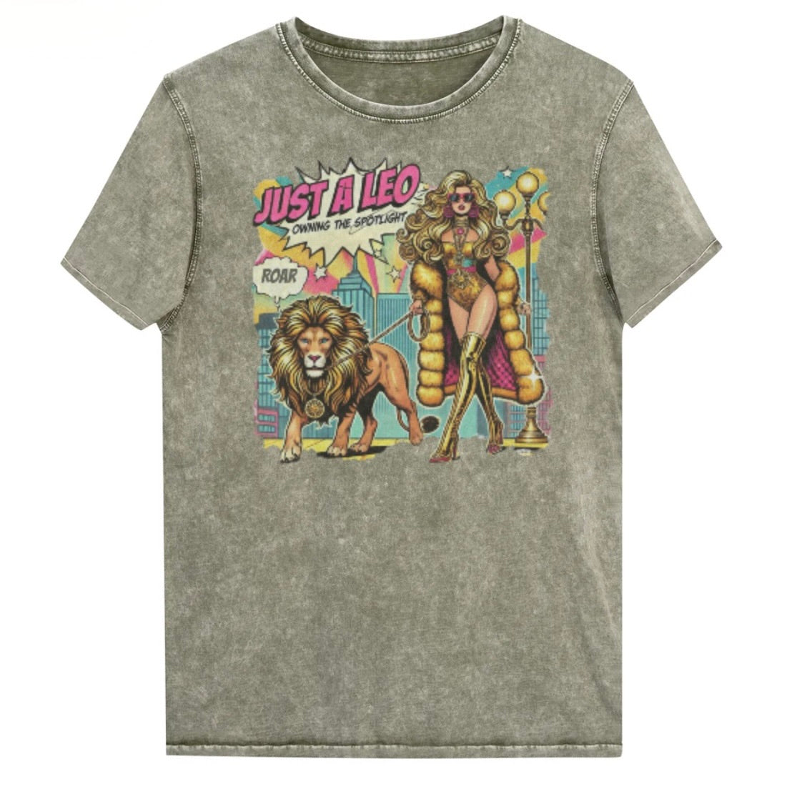 Flatlay of a unisex army green denim wash vintage t-shirt with a retro pop-art Leo graphic featuring a long curly haired blonde woman in a gold swimsuit, gold over the knee boots, gold medallion and long fur coat, walking a lion on a leash wearing a gold medallion, with a caption bubble 'Roar', with a city and round bulb street lights in the background captioned ‘Just a Leo, Owning the Spotlight'. Branded RedBlonde on inside neck and right shoulder
