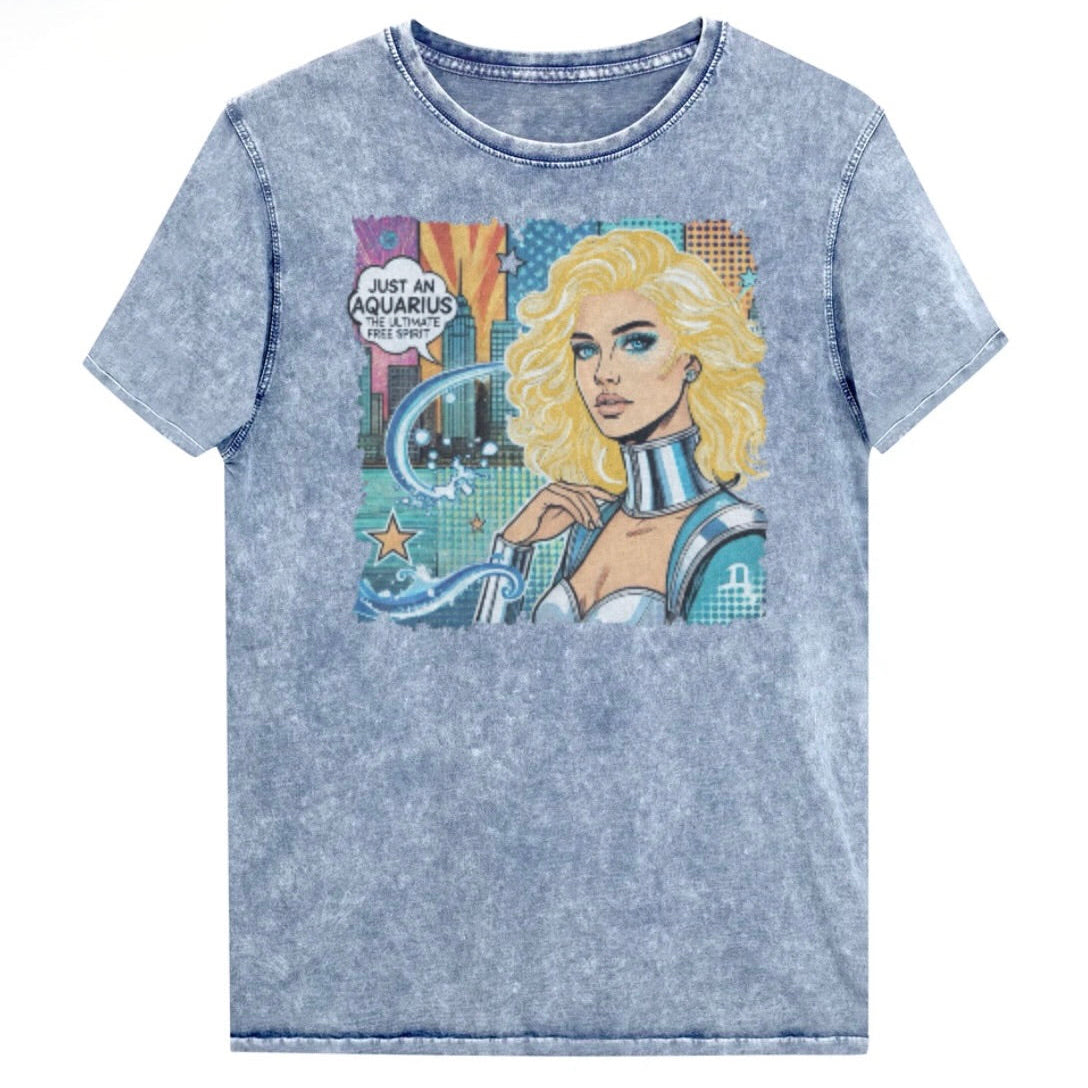 Flatlay of a blue denim vintage denim-wash unisex t-shirt with a retro pop-art Aquarius graphic showing the head and shoulders of a blonde woman with blue highlights wearing a sci-fi type silver choker and outfit, with a city background with tentacles and stars captioned, "Just an Aquarius, the ultimate free spirit". Branded Redblonde in red on inside neck and right shoulder