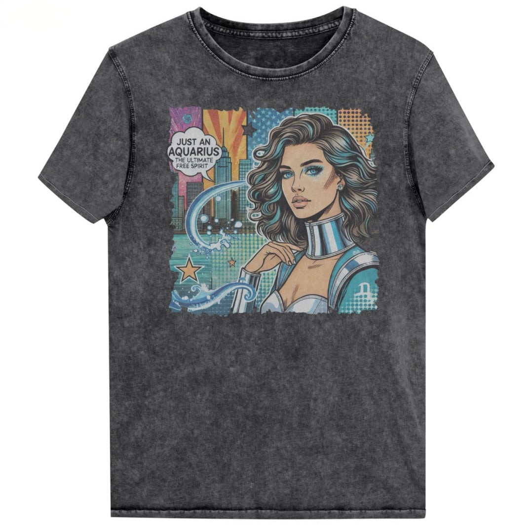Flatlay of a black vintage denim-wash unisex t-shirt with a retro pop-art Aquarius graphic showing the head and shoulders of a brunette woman with blue highlights wearing a sci-fi type silver choker and outfit, with a city background with tentacles and stars captioned, "Just an Aquarius, the ultimate free spirit". Branded Redblonde on inside neck and right shoulder