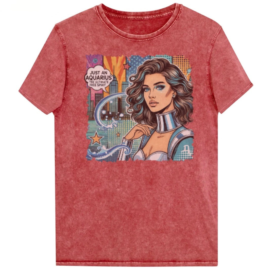 Flatlay of a red vintage denim-wash unisex t-shirt with a retro pop-art Aquarius graphic showing the head and shoulders of a brunette woman with blue highlights wearing a sci-fi type silver choker and outfit, with a city background with tentacles and stars captioned, "Just an Aquarius, the ultimate free spirit". Branded Redblonde on inside neck and right shoulder