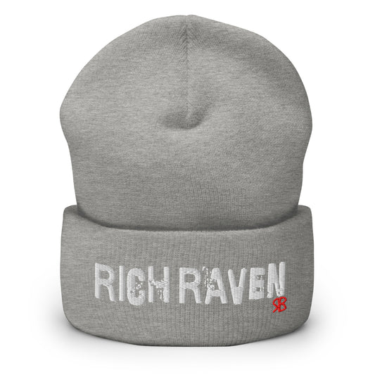 Light Grey Rich Brunette knitted beanie with the embroidered phrase “Rich Raven” in white script and a small red RB logo on the fold-over cuff, displayed against a clean white background.