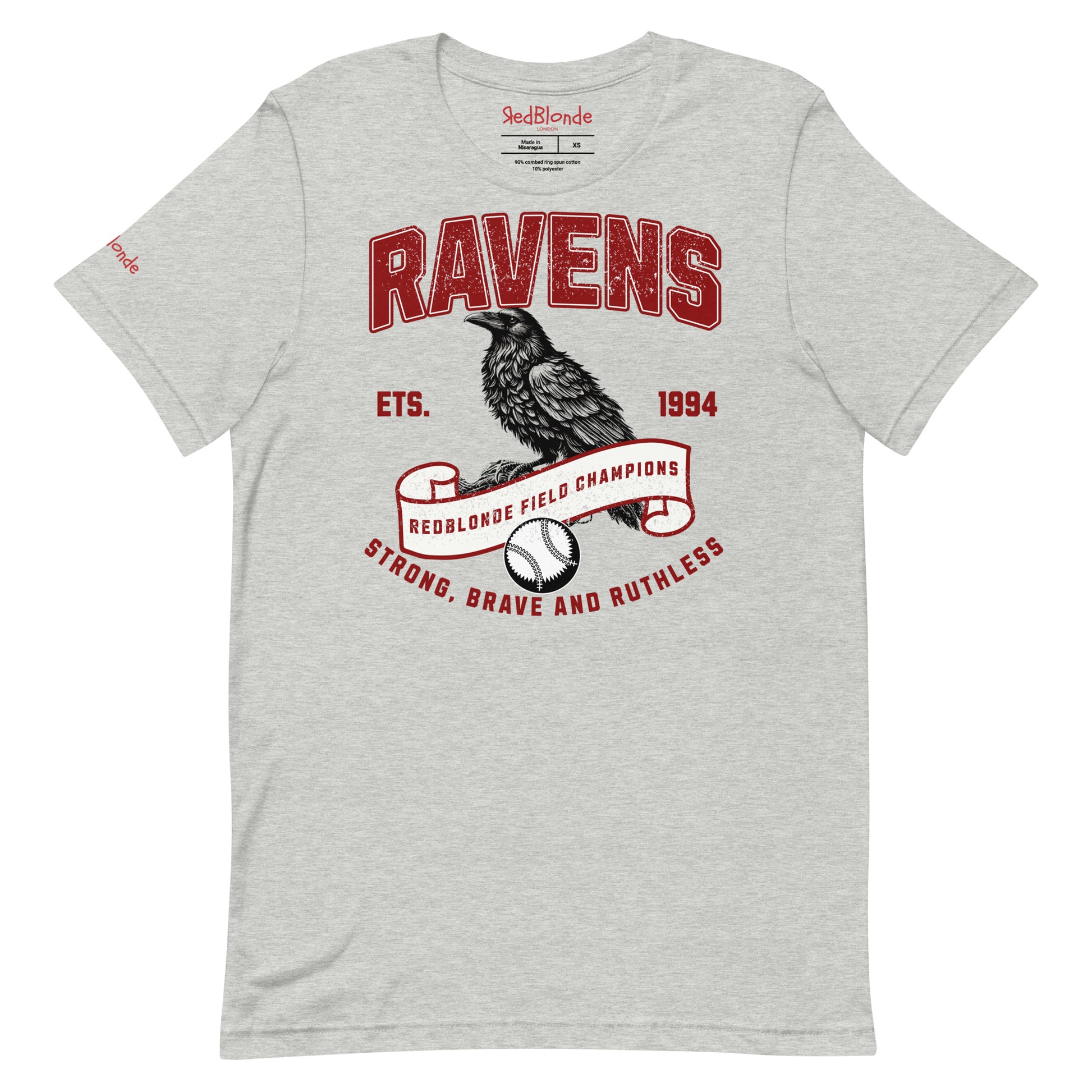 Light grey unisex t-shirt featuring a bold american collegiate vintage-style graphic with the word "RAVENS" in distressed red lettering. Below, a detailed black raven illustration perches on a scroll that reads "REDBLONDE FIELD CHAMPIONS," with a baseball beneath it. Additional text includes "ETS. 1994" and the phrase "STRONG, BRAVE AND RUTHLESS" in red. RedBlonde branding appears on the inner neck label and left sleeve in red text.