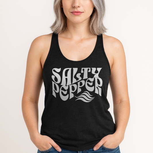 Model with silver gray hair wears a heather black soft racerback tank t-shirt with 'Salty Pepper' play on words slogan in white retro wavy 70s font.  Branded RedBlonde London on reverse