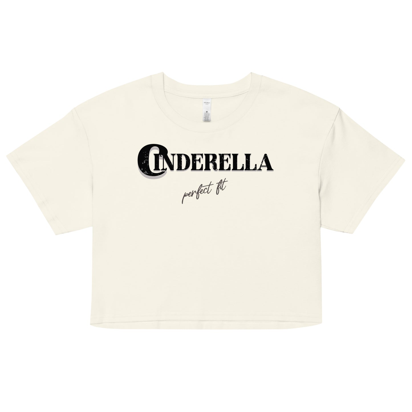 Natural-colored women’s crop top featuring black merger text that reads “Cinderella” with a decorative crescent moon incorporated into the letter C, and the phrase “perfect fit” written underneath in an elegant cursive script.