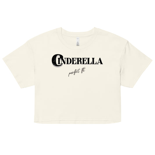 Natural-colored women’s crop top featuring black merger text that reads “Cinderella” with a decorative crescent moon incorporated into the letter C, and the phrase “perfect fit” written underneath in an elegant cursive script.