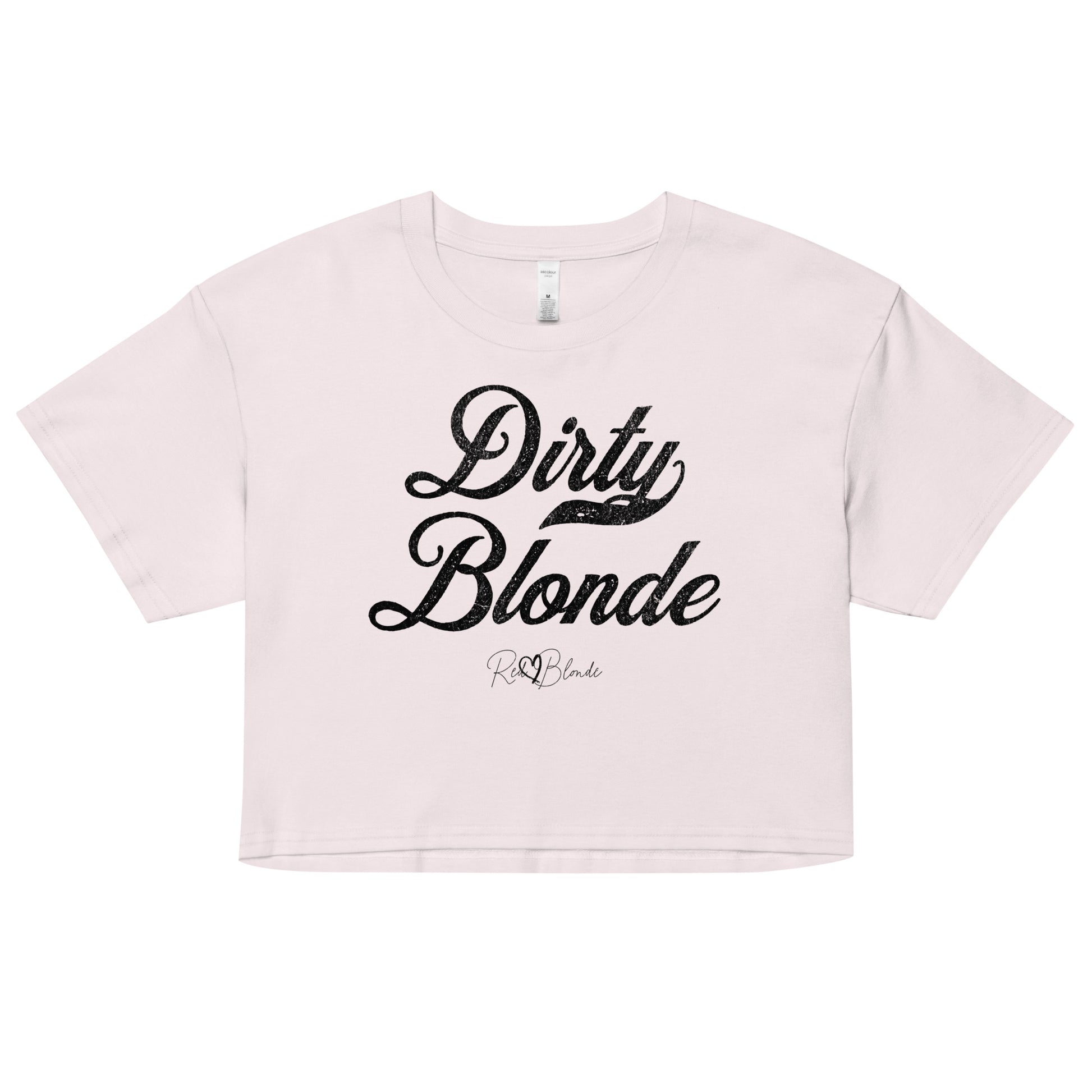 Orchid women’s crop top featuring the phrase “Dirty Blonde” in bold, black milkstore vintage-style script across the chest. Below the phrase, the brand name “RedBlonde” is printed in a smaller, elegant handwritten font.