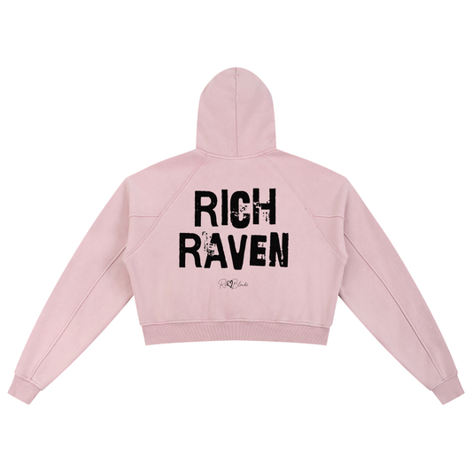 Back view of a cropped snow-wash pale pink hoodie with bold black “RICH RAVEN” Ed Gein font and the RedBlonde signature logo printed below.