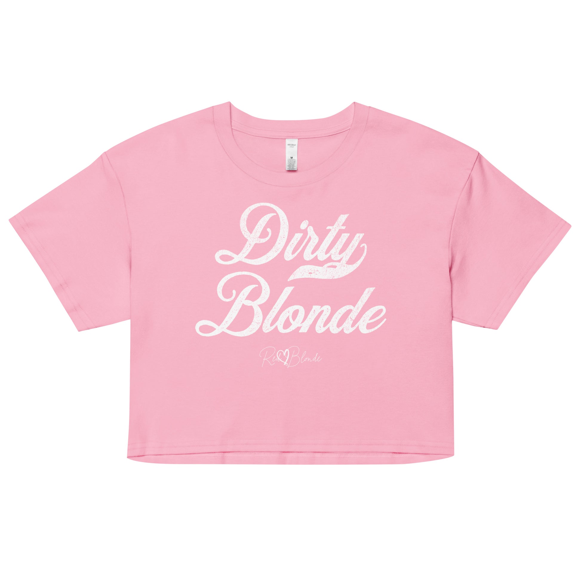 Pink women’s crop top featuring the phrase “Dirty Blonde” in bold, white milkstore vintage-style script across the chest. Below the phrase, the brand name “RedBlonde” is printed in a smaller, elegant handwritten font.