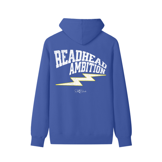 Royal blue hoodie featuring bold white vintage-textured TRICOT font lettering that reads “Redhead Ambition” across the back, with a yellow lightning bolt graphic underneath and the RedBlonde signature logo printed below.