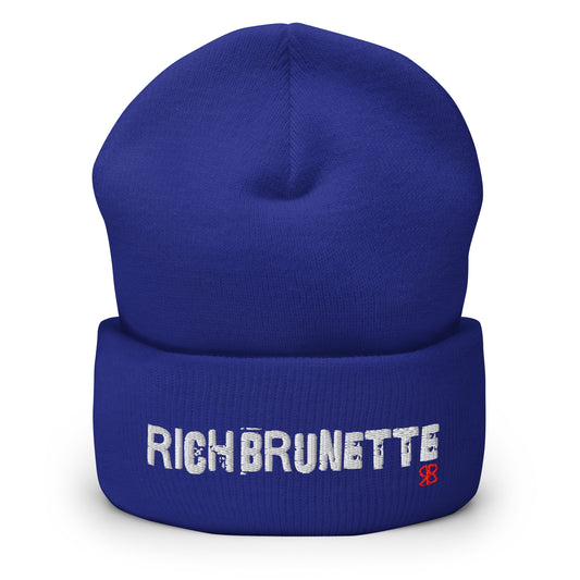 Royal Blue Rich Brunette knitted beanie with the embroidered phrase “Rich Brunette” in white script and a small red RB logo on the fold-over cuff, displayed against a clean white background.