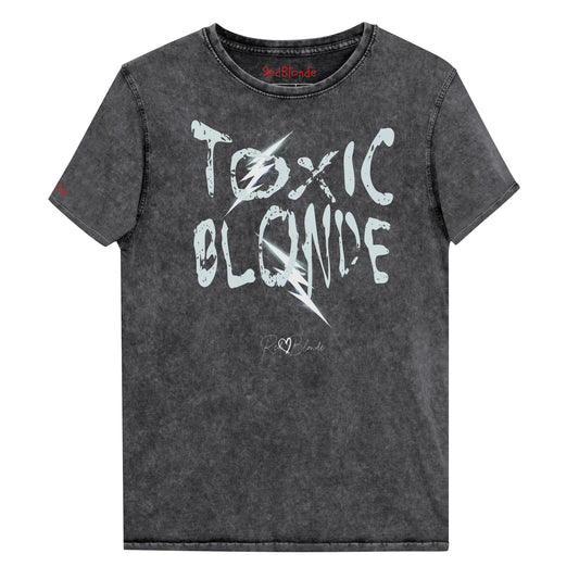 Black acid-wash denim-style unisex t-shirt with the bold graphic text “TOXIC BLONDE” in distressed light blue Chainsaw Carnage lettering across the front, featuring the RedBlonde logo subtly printed below the text. Branded RedBlonde in red in inside neck and right sleeve