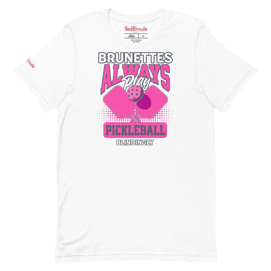 White unisex t-shirt with bold pink and white graphic that says "Brunettes Always Play Pickleball Blindingly," featuring two pink pickleball paddles and a ball. Branded RedBlonde on inside neck and right sleeve