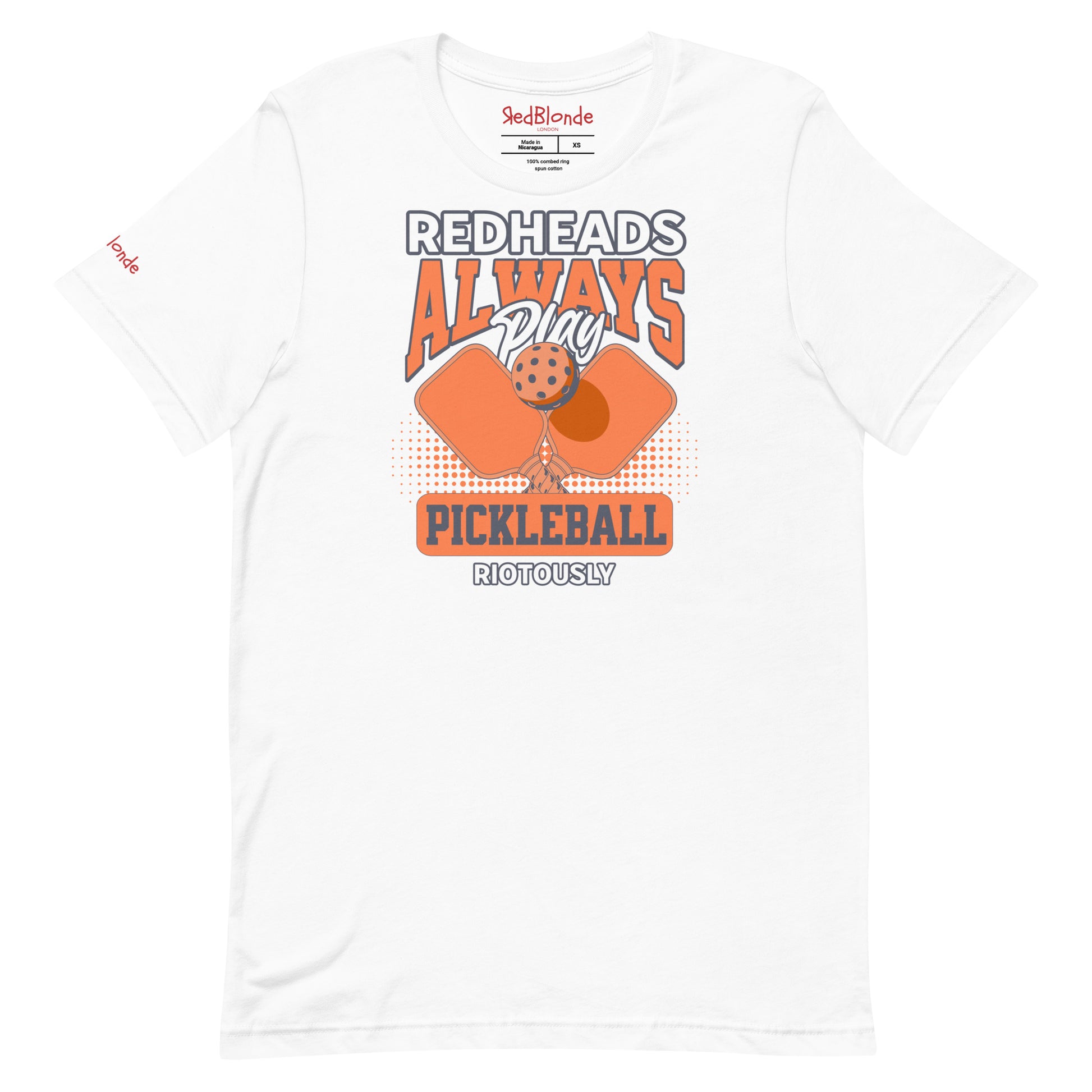 White unisex t-shirt with orange graphic that reads "Redheads Always Play Pickleball Riotously," featuring pickleball paddles and ball. Branded RedBlonde on inside neck and right sleeve