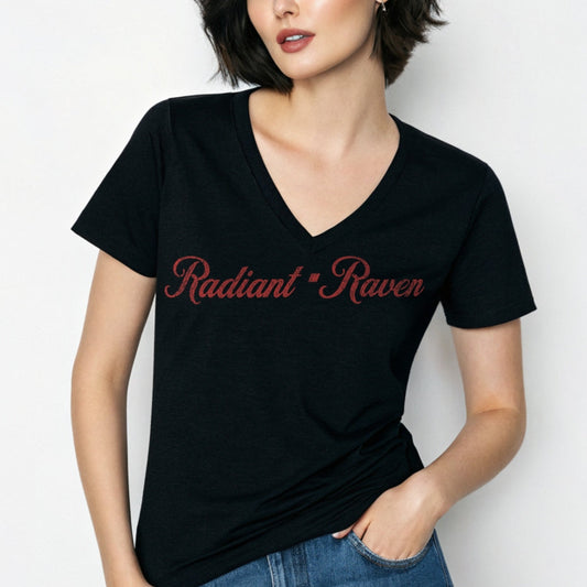 Woman with black hair wears black women's relaxed fit v-neck slogan t-shirt with 'Radiant Raven' in milkshake script red font. Branded RedBlonde in red on inside neck and right sleeve