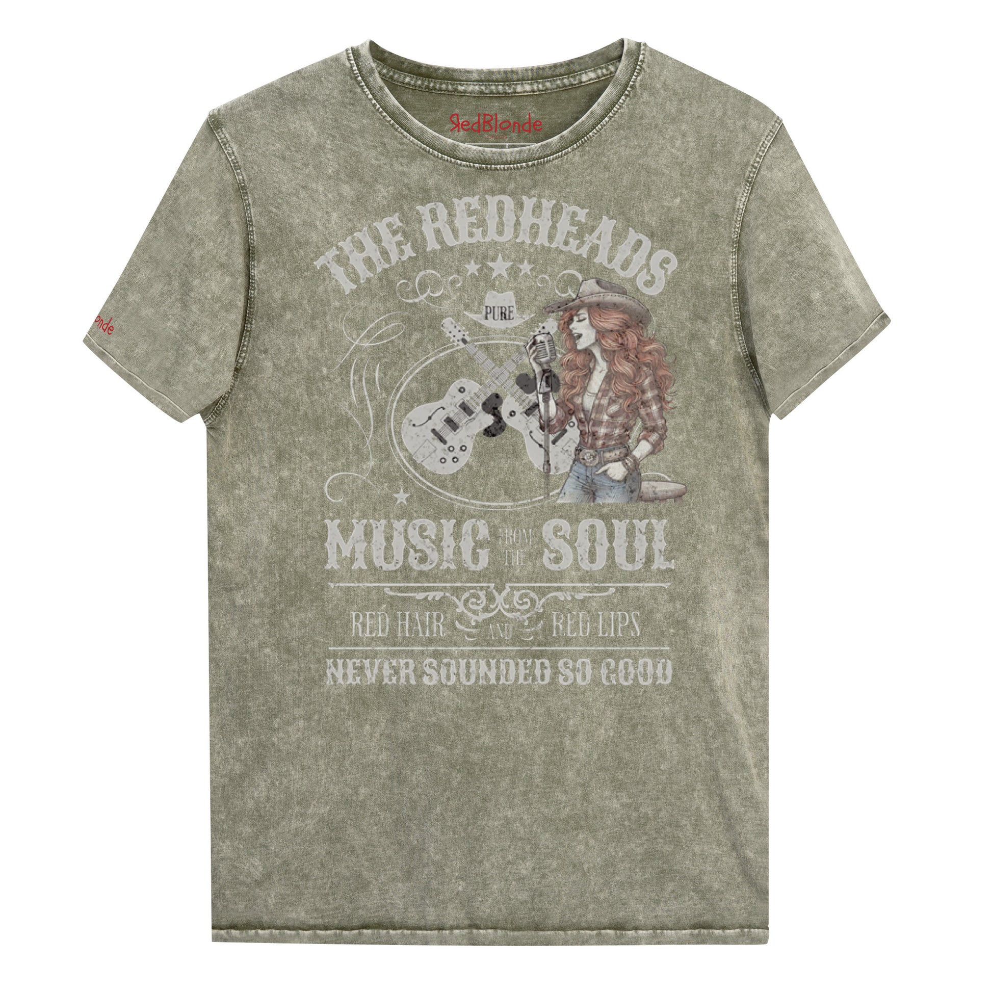 An army green denim wash unisex t-shirt with ‘THE REDHEADS’, ‘MUSIC FROM THE SOUL’, ‘RED HAIR AND RED LIPS’, and ‘NEVER SOUNDED SO GOOD’ written in Sancreek font features a graphic of a redheaded cowgirl singing with two guitars behind her. Branded RedBlonde London in red on inside neck and right sleeve 