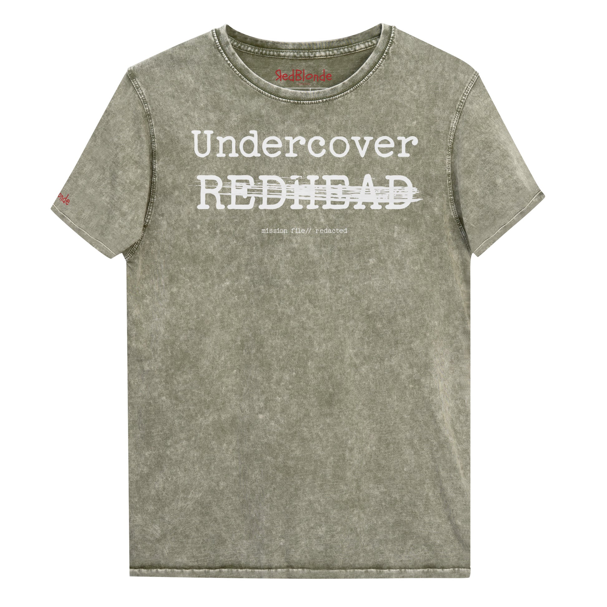An army green unisex denim-style t-shirt with a vintage washed finish. The front features bold white text reading “Undercover REDHEAD” partially struck through by a horizontal white bar. Beneath it, smaller text says “mission file // redacted” along with a subtle RedBlonde logo. The shirt has a classic crew neck and short sleeves with visible stitching for a rugged look. Branded RedBlonde London in red on inside neck and right sleeve