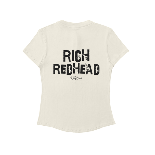Back view of a beige slightly fitted women’s henley T-shirt with short sleeves and a gently curved hem. Centered on the upper back is bold distressed black Ed Gein text reading “RICH REDHEAD” with a small RedBlonde signature script logo beneath it. The shirt is shown on a plain white background.