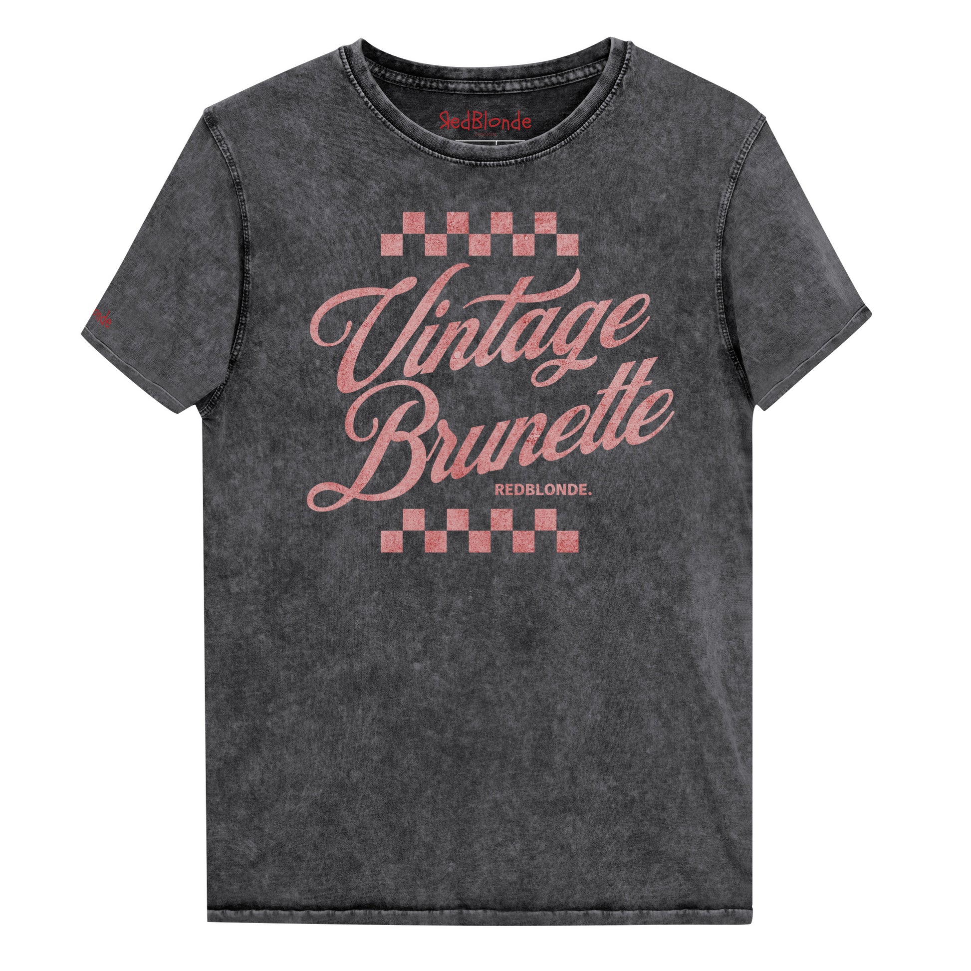 black acid wash short-sleeve T-shirt featuring the bold red Milkstore 1 script text “Vintage Brunette” across the chest with checkerboard accents above and below the lettering. The brand name “RedBlonde.” is printed in small capital letters beneath the word “Brunette.” The shirt has a casual, slightly distressed look with visible stitching along the seams. Branded RedBlonde on inside collar and right sleeve