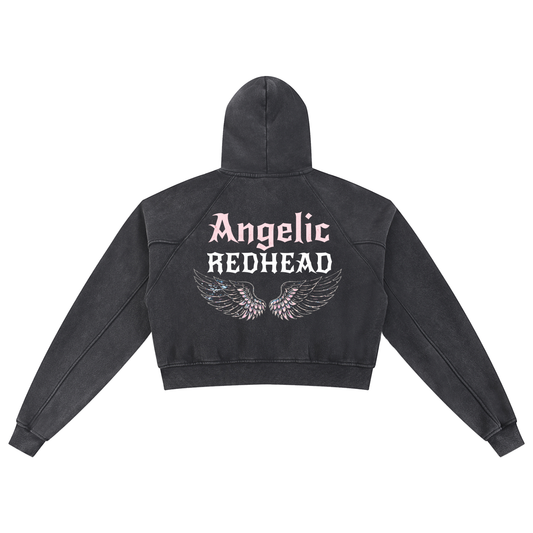 Back view of a black cropped hoodie with hood up, featuring “Angelic Redhead” New Rocker font text and iridescent angel wings graphic printed across the back on a white background.