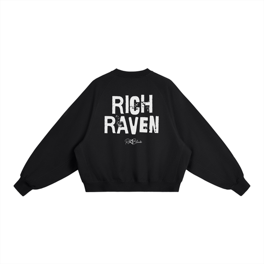 Black oversized dolman-sleeve sweatshirt shown from the back on a plain white background. It has a boxy, relaxed fit with dropped shoulders, ribbed crew neckline, ribbed cuffs, and a ribbed hem band. Centered on the back is a distressed white “RICH RAVEN” Ed Gein graphic with a small “RedBlonde” script logo beneath.