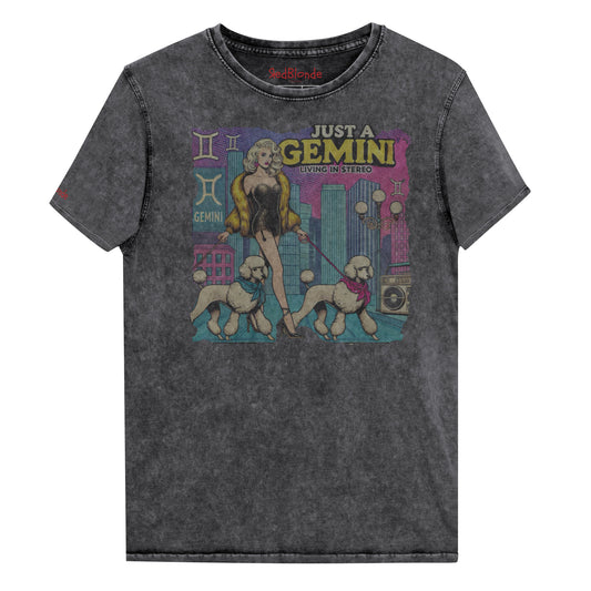 Flatlay of a unisex black denim wash vintage t-shirt with a retro pop-art Gemini graphic featuring a blonde woman, in a short catsuit and fur coat walking two poodle dogs with neck scarfs with a city backdrop and a gettoblaster ‘Just a Gemini, Living in Stereo'. Branded RedBlonde on inside neck and right shoulder