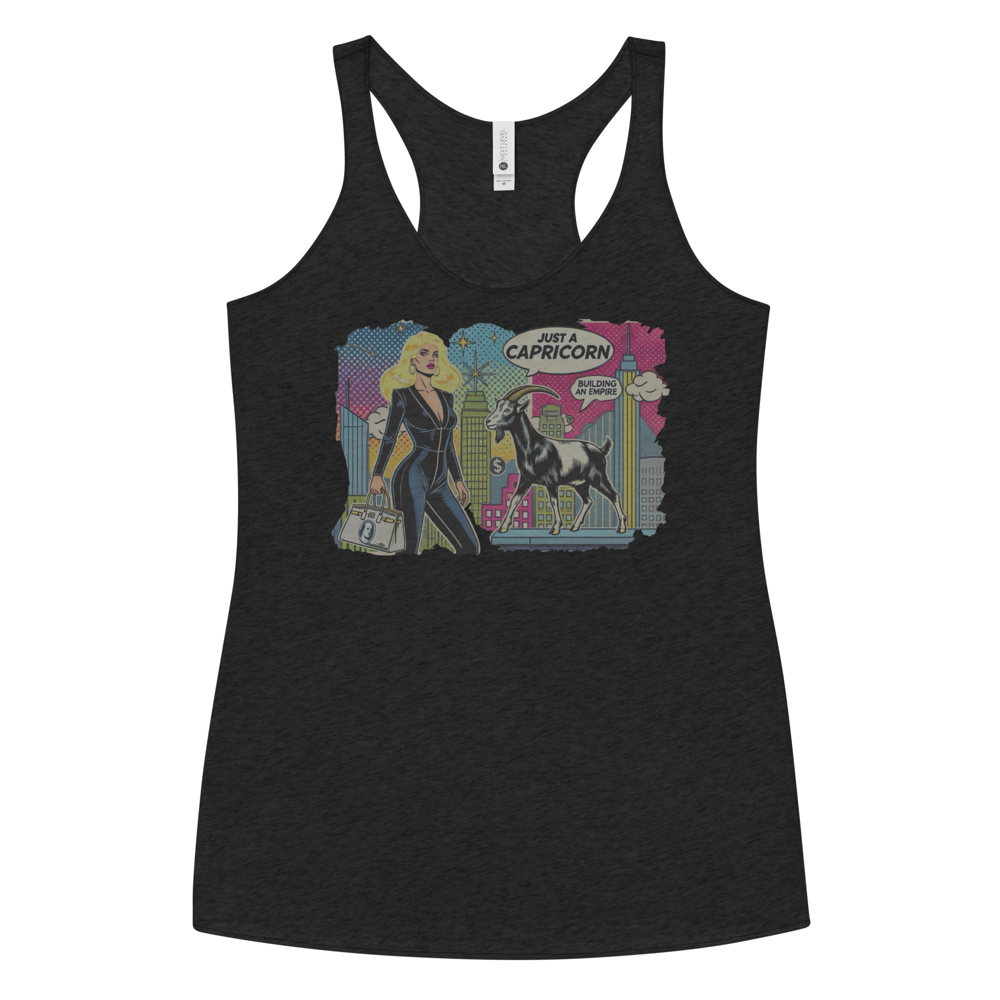 Flatlay of a heather black soft racerback tank t-shirt with a retro pop-art Blonde Capricorn graphic featuring a blonde woman in a black catsuit, carrying a bag, with a goat  and a city skyscraper backdrop, captioned ‘Just a Capricorn, Building an empire'