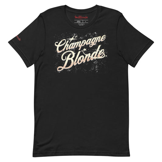 Flatlay of black unisex relaxed fit t-shirt with 'Champagne Blonde' on an angle in Milkstore 01 font in a golden hue with a sprinkle of distressed stars. Branded RedBlonde London in red on inside neck and right sleeve.