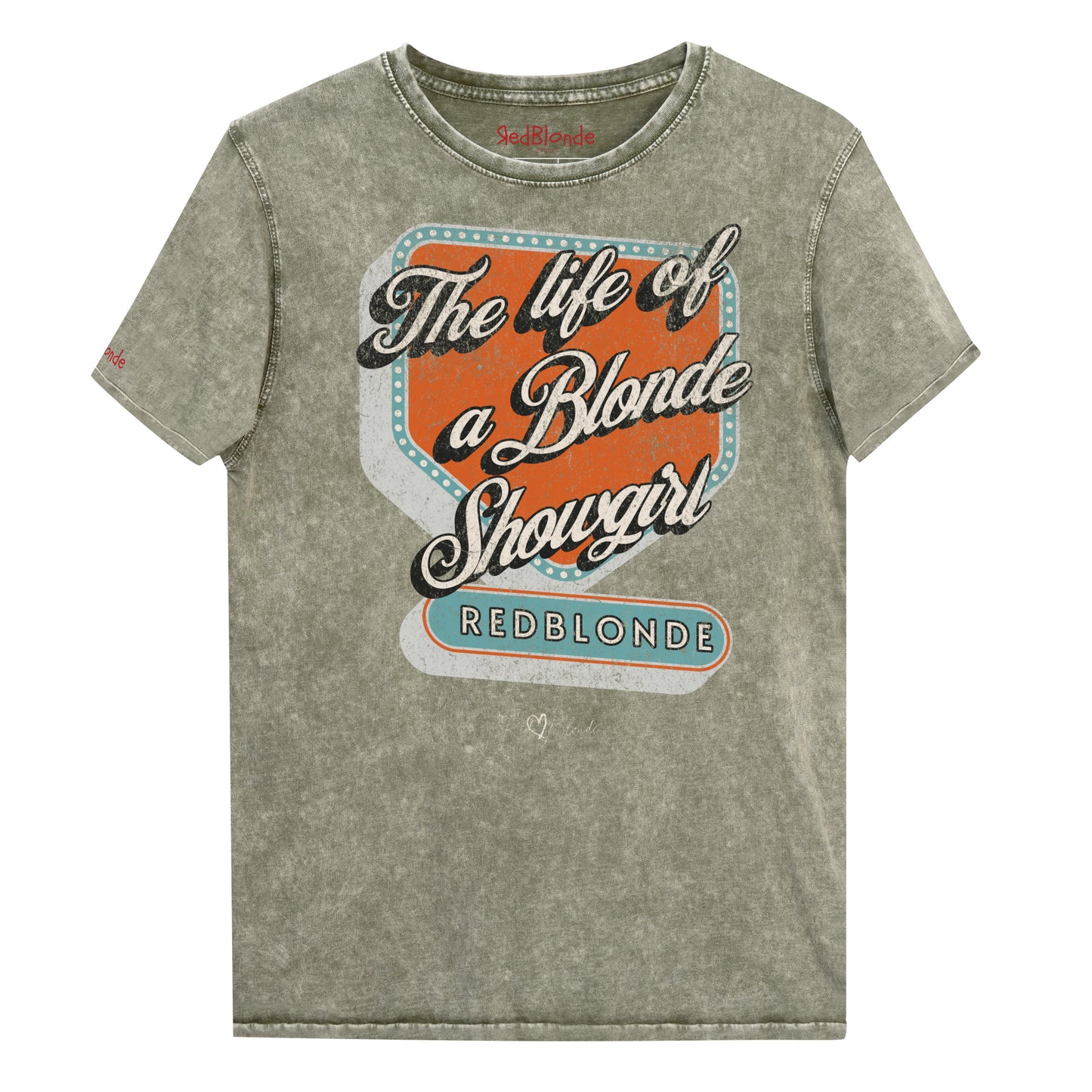 Vintage army green acid-wash unisex t-shirt with bold retro-style graphic text reading 'The life of a Blonde Showgirl' in white script over an orange and turquoise marquee design. The word 'RedBlonde' is displayed in turquoise block letters at the bottom, with subtle worn details giving the shirt a distressed, retro look." Branded redblonde on inside collar and right sleeve
