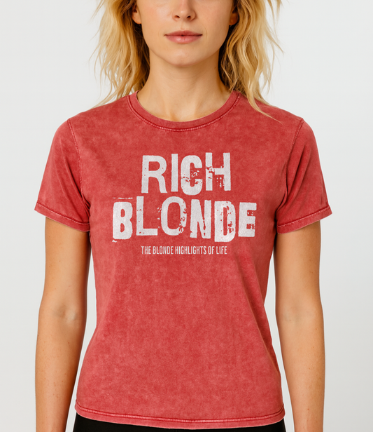 Blond wears a red acid-wash unisex denim T-shirt with a distressed vintage look. The shirt features the bold white text “RICH BLONDE” in a weathered Ed Gein font, with the tagline “THE BLONDE HIGHLIGHTS OF LIFE” in smaller uppercase letters below. The shirt has short sleeves, a crew neckline, and visible seam detailing for a rugged, casual style. Branded Redblonde on inside neck and right sleeve