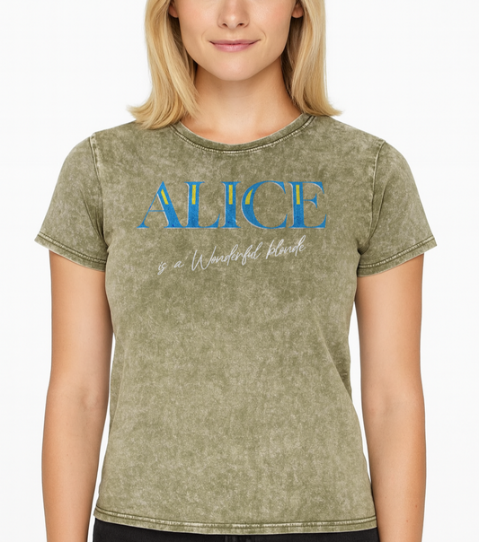 Blonde wears a Dark army green acid-wash unisex T-shirt with bold blue Glook text “ALICE” across the chest. Beneath it, in elegant white script, it reads “is a Wonderful Blonde.” The inside neck and sleeve also feature the RedBlonde logo in red.