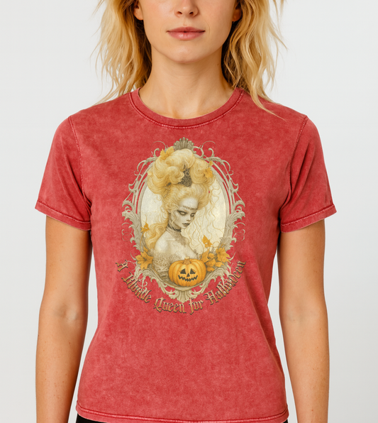 blonde wears a red garnet acid-wash unisex T-shirt featuring a gothic-style illustration of blonde-haired woman with an elaborate beehive hairstyle, framed by ornate scrollwork, autumn leaves, and a carved pumpkin. The design is captioned with the text ‘A Blonde Queen for Halloween’ in vintage Dark Angle lettering. Branded RedBlonde in red on inside neck and right sleeve