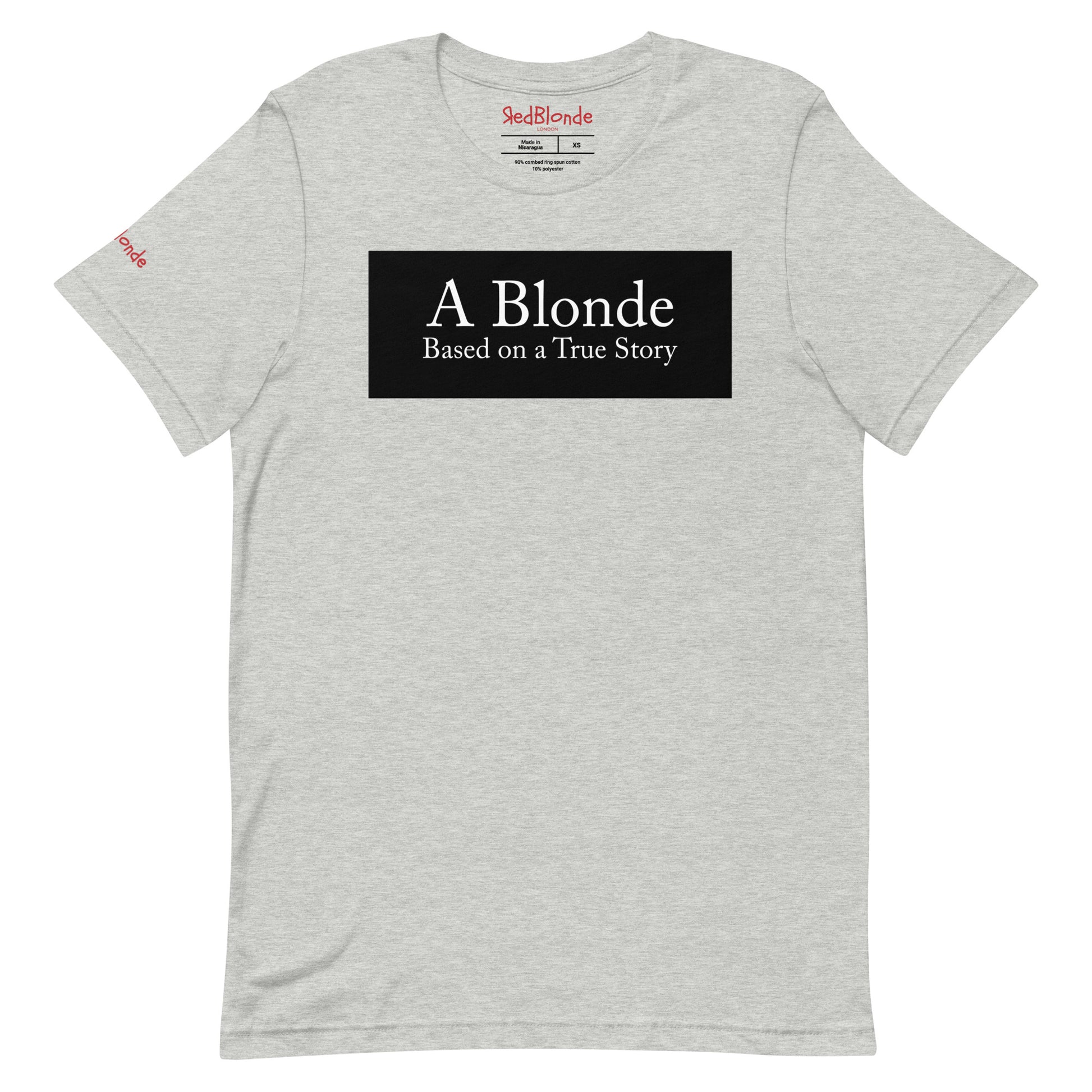 flatlay of a heather athletic grey unisex relaxed fit t-shirt with the slogan 'A Blonde. Based on a True Story' in white text in a black box graphic. Branded RedBlonde London in red on inside neck and right sleeve 