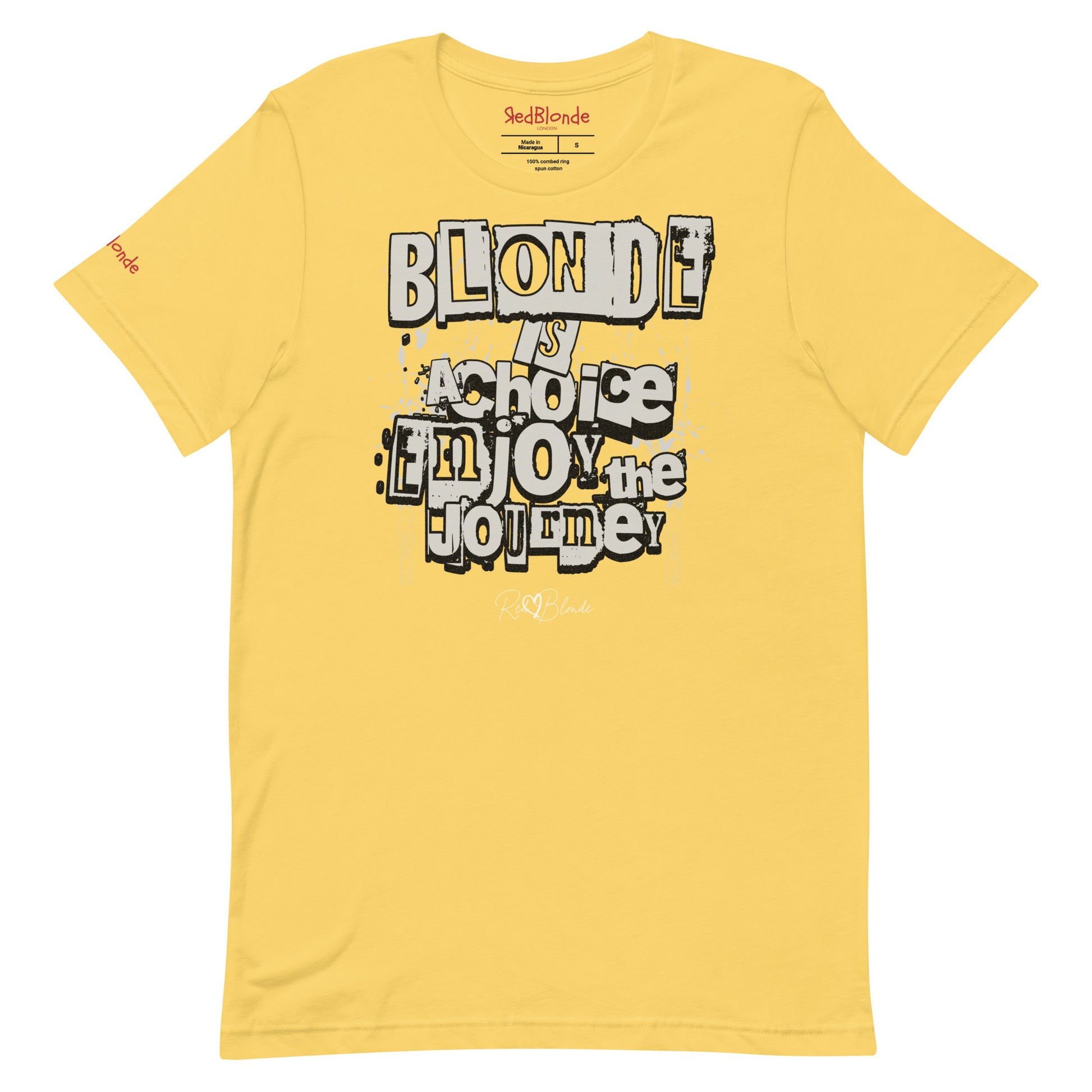 A bright yellow unisex T-shirt with a classic crew neckline and short sleeves. The front displays a bold, graffiti-style text design in black, white, and gray. The words read: “BLONDE is a choice, ENJOY the JOURNEY” with varied fonts and a layered street-art effect. The RedBlonde brand name is subtly printed below in a handwritten script. Branded RedBlonde london in red on inside neck and right sleeve