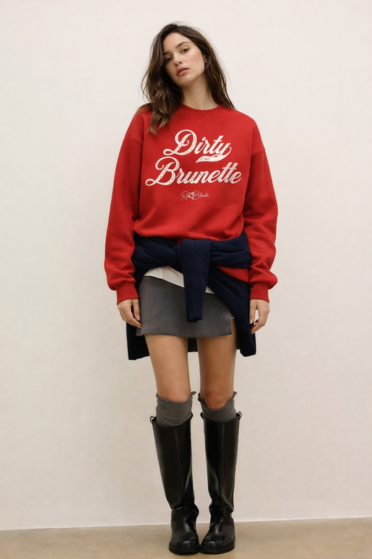 Brunette wears a red Classic relaxed fit premium unisex sweatshirt with the playful slogan ‘Dirty Brunette’ in white milk-store font, signed off RedBlonde. 