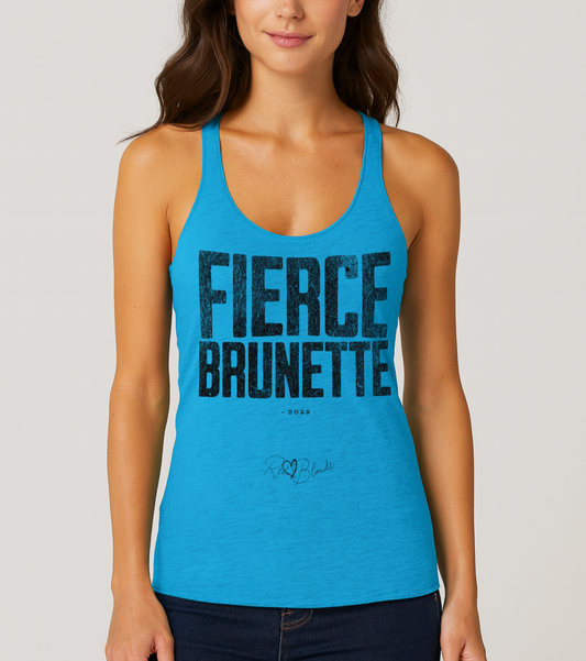 brunette wears a vintage turquoise women’s racerback tank top with the bold, distressed North Road font text  "FIERCE BRUNETTE" in large uppercase white letters across the chest. Below it, in smaller white text, is “• 2025 •” followed by a script-style signature reading “RedBlonde.”