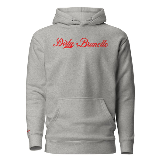 Flatlay of a carbon grey relaxed fit unisex hoodie with the words 'dirty Brunette' written in red vintage milkstore font, like coco cola script. Branded RedBlonde London in red on inside neck and right sleeve 