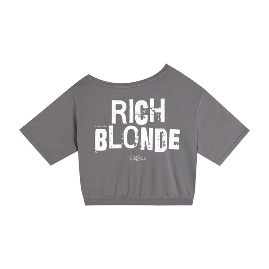 grey asymmetrical shoulder t-shirt with bold white Ed Gein font “RICH BLONDE" slogan on the front and RedBlonde logo beneath.
