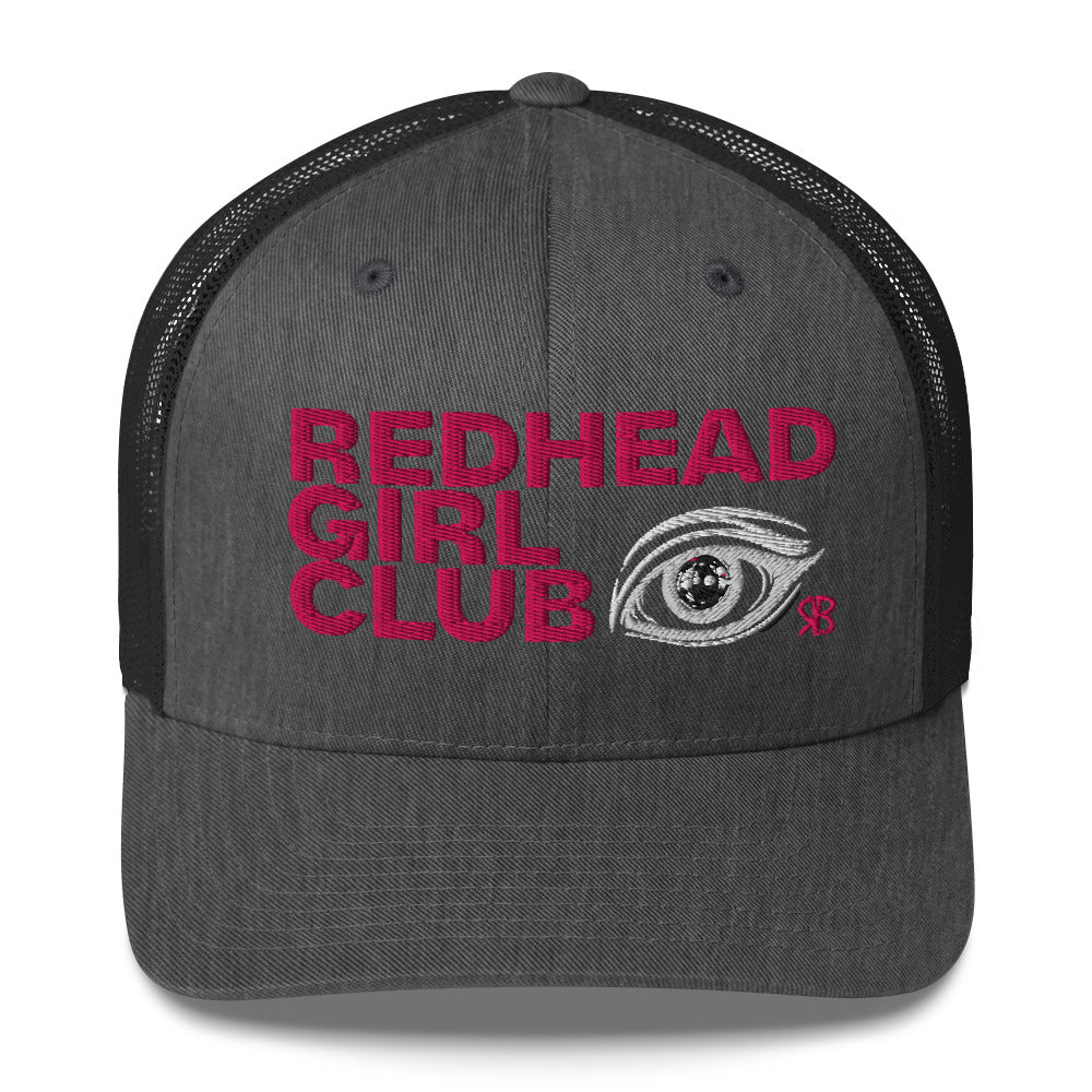 grey/black mesh trucker hat featuring bold red embroidered text “Redhead Girl Club” alongside a detailed embroidered eye graphic and a small red RB logo.
