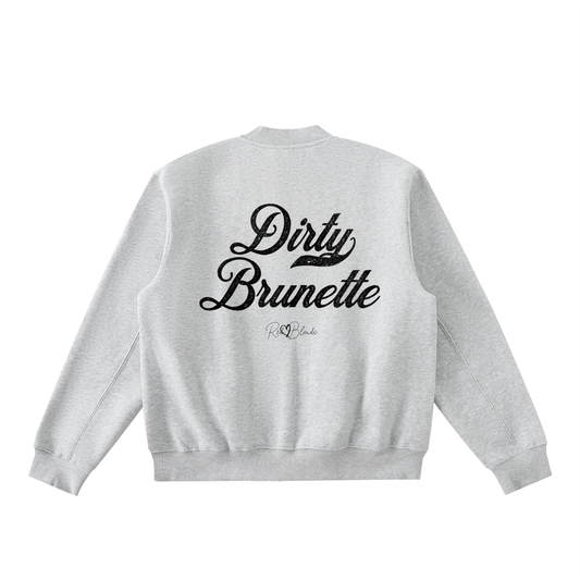 The back of a gray crewneck zip up varsity jacket  laid flat on a white background. It has ribbed cuffs, collar, and hem. Large black Milkstore 01 script text across the back reads “Dirty Brunette,” with a small cursive RedBlonde logo beneath.