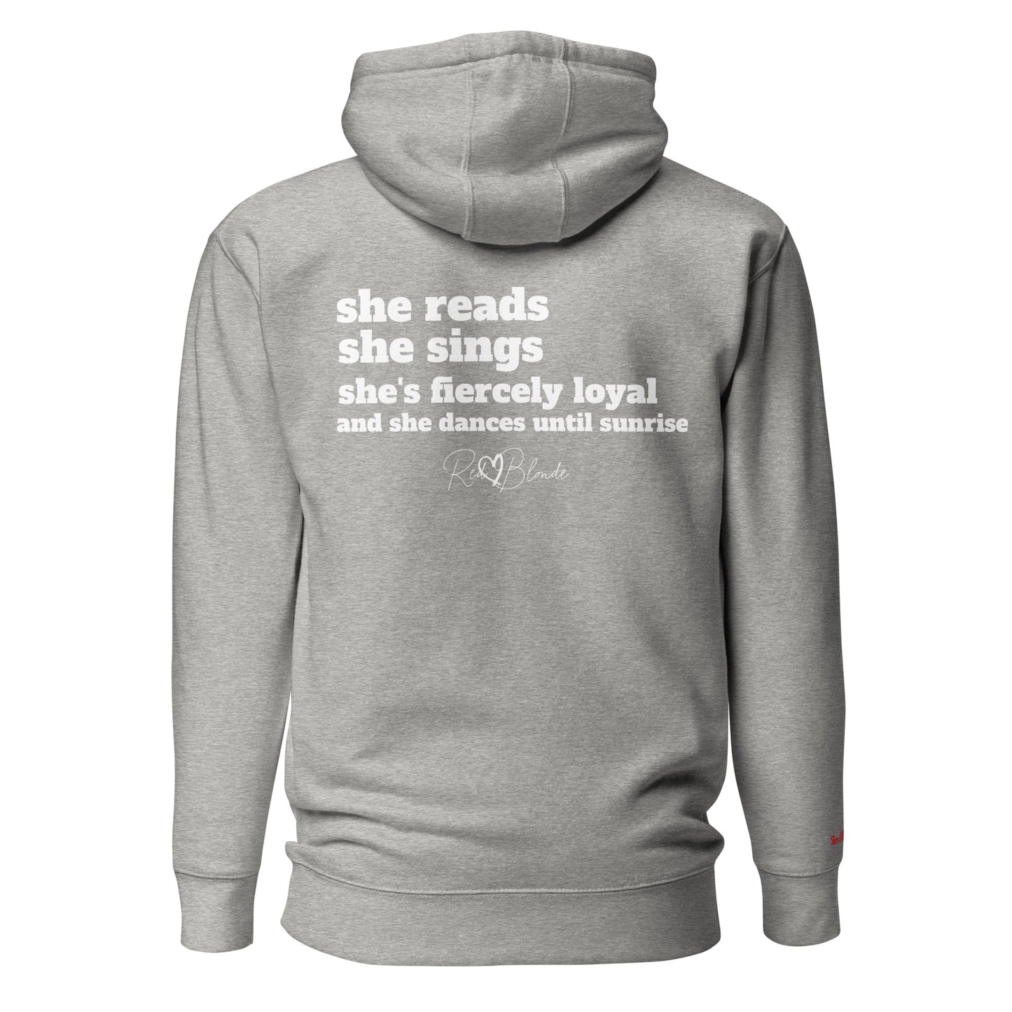 Back view of a grey unisex hoodie featuring white text that reads, “she reads, she sings, she’s fiercely loyal, and she dances until sunrise,” with the RedBlonde logo printed underneath. The design conveys confidence and personality with a bold, uplifting message.